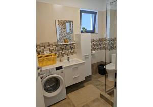 a bathroom with a washing machine and a sink at Apartament Passion in Mamaia Sat/Năvodari