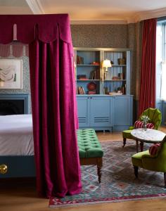 a bedroom with a bed with a red curtain at The Mitre, Hampton Court in Kingston upon Thames
