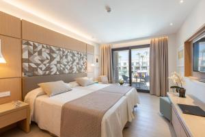 a hotel room with a bed and a desk at Hipotels Barrosa Park in Chiclana de la Frontera