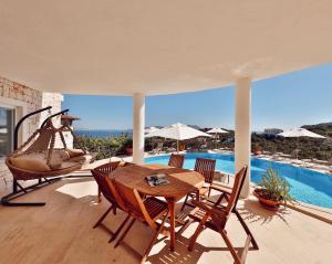 a patio with a table and chairs and a pool at Hill House Adult Only in Kaş