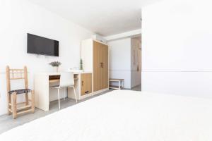 a white room with a desk and a tv at Villa Torre Dell'Altomare con piscina, blocco n2 - Apulia Home in Alliste
