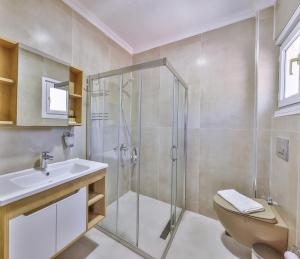 a bathroom with a shower and a toilet and a sink at Hill House Adult Only in Kaş