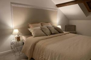 a bedroom with a large bed with two pillows at Un petit coin sous les toits in Épernay