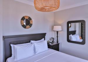 a bedroom with a white bed and a mirror at Hill House Adult Only in Kaş