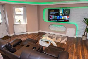 a living room with a couch and a flat screen tv at Optimal Apartments in Bradford