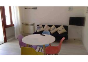 a living room with a table and chairs and a couch at Bilocale a pochi metri dal mare in La Maddalena