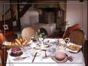 uma mesa com uma toalha de mesa branca com comida e uma lareira em La Croix de Saburin em Quincié-en-Beaujolais