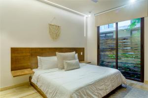a bedroom with a large bed and a large window at Private pool apartment for groups in Tulum +34 photos