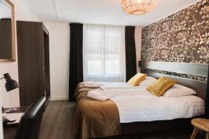 a bedroom with a large bed and a large window at Hanze Hotel Zwolle in Zwolle