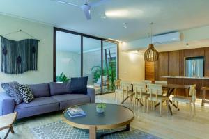 a living room with a couch and a table at Private pool apartment for groups in Tulum