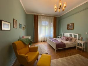 ein Schlafzimmer mit einem Bett, einem Stuhl und einem Kronleuchter in der Unterkunft City Stay Timisoara in Timişoara