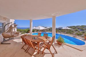 a patio with a table and chairs and a pool at Hill House Adult Only in Kaş