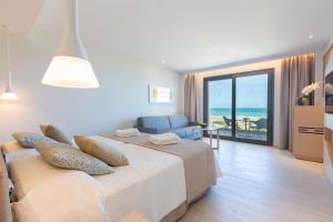 a bedroom with a bed and a view of the ocean at Hipotels Barrosa Park in Chiclana de la Frontera