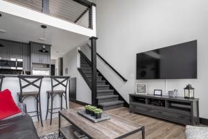 a living room with a couch and a table and a tv at Center City Lofts 508 Unit 2 Close to Downtown and the TART Trail in Traverse City