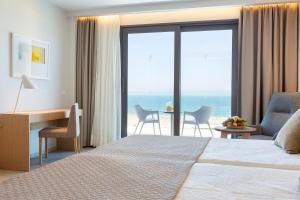 a hotel room with a bed and a desk with a view at Hipotels Barrosa Park in Chiclana de la Frontera