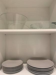 a shelf with a stack of plates and a bowl at Notodden Sentrum Apartment NO 4 in Notodden