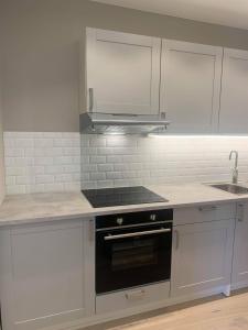 a kitchen with white cabinets and a stove top oven at Notodden Sentrum Apartment NO 4 in Notodden +21 photos