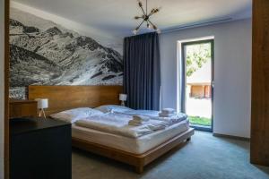 a bedroom with a bed with a mountain mural on the wall at Penzión DEER in Stará Turá