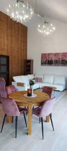 a dining room with a wooden table and pink chairs at Ravila Puhkemaja in Kuressaare