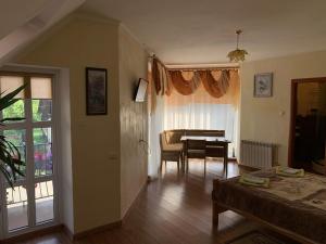 a living room with a table and a dining room at Дідів Рай in Volovets
