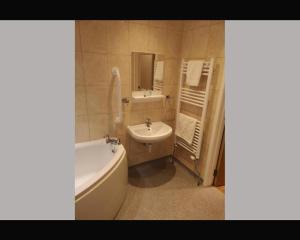 a bathroom with a tub and a sink and a bath tub at The R Inn Hotel in Desborough