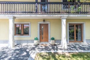 una casa con dos jarrones delante de una puerta en Villa HerMes ArT, en Dutovlje