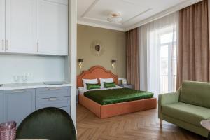 a bedroom with a bed and a couch and a chair at Dom Dehtereva in Saint Petersburg