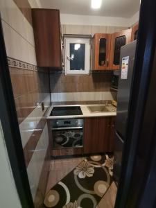 a small kitchen with a stove and a sink at Apartament Central Băile Herculane in Băile Herculane