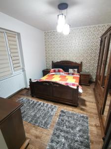 a bedroom with a bed and two rugs at Apartament Central Băile Herculane in Băile Herculane