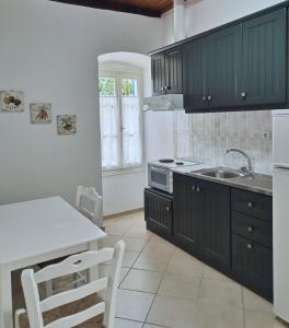 een keuken met zwarte kasten en een wit aanrecht bij Spilia in Stavros