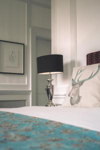 een slaapkamer met een bed met een lamp erop bij Warbrook House Heritage Hotel in Hook