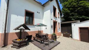 un patio con mesa, banco y sombrilla en Pension Plestil, en Liberec