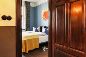 - une chambre avec un lit aux murs bleus dans l'établissement Villa 1912, à Bad Zwischenahn