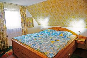 1 dormitorio con cama de madera y edredón azul en Ferienhaus Aßmus en Weißenburg in Bayern