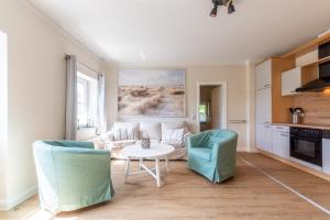 een woonkamer met een bank en 2 stoelen bij An der Steilküste Wohnung 01 in Boltenhagen