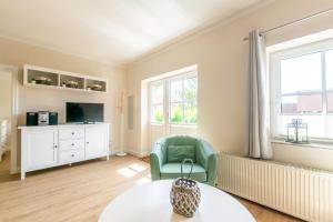 een woonkamer met een tafel en een groene stoel bij An der Steilküste Wohnung 01 in Boltenhagen
