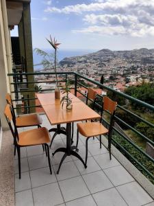 una mesa y sillas en un balcón con vistas en pietro family apartment, en Funchal