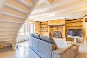 ein Wohnzimmer mit Couch und Kamin in der Unterkunft Villa avec piscine sur le domaine d'un château in Carsac-Aillac
