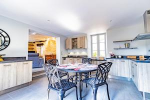 eine Küche und ein Esszimmer mit Tisch und Stühlen in der Unterkunft Villa avec piscine sur le domaine d'un château in Carsac-Aillac