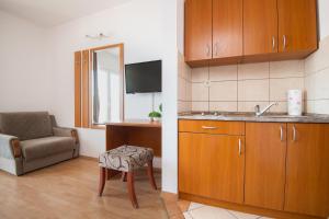 a kitchen with a sink and a chair in a room at Apartments Knežević in Neum