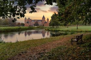 a park bench in front of a castle with a river at B&B by the C in Vlissingen