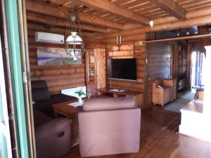a living room with a table and a tv in a cabin at Meseház Apartman in Zalalövő