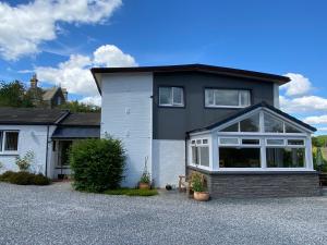 ein schwarzes und weißes Haus mit vielen Fenstern in der Unterkunft Stables Guest House in Newton Stewart