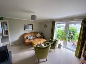 a living room with a couch and chairs and a table at Stables Guest House in Newton Stewart