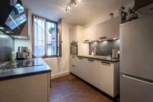 uma cozinha com armários brancos e uma grande janela em Le Puit Saint Jean 3 - Apartment for 2-4 people em Annecy