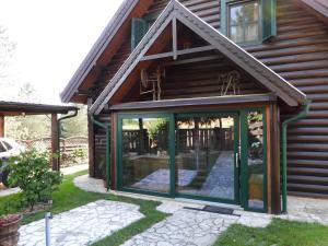 a house with glass doors on the side of it at Meseház Apartman in Zalalövő +13 photos