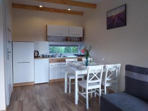 a kitchen and dining room with a table and chairs at Domki Anusia Niechorze in Niechorze