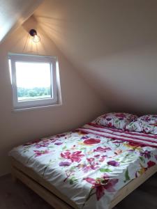 a bedroom with a bed with flowers on it at Domki Anusia Niechorze in Niechorze