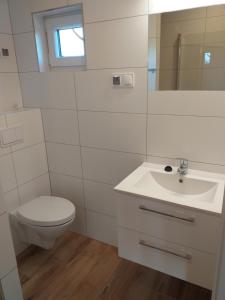 a white bathroom with a toilet and a sink at Domki Anusia Niechorze in Niechorze +8 photos