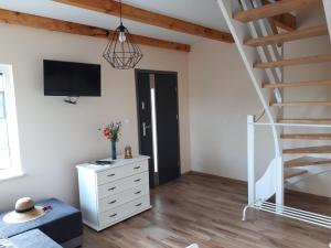 a living room with a staircase and a dresser at Domki Anusia Niechorze in Niechorze